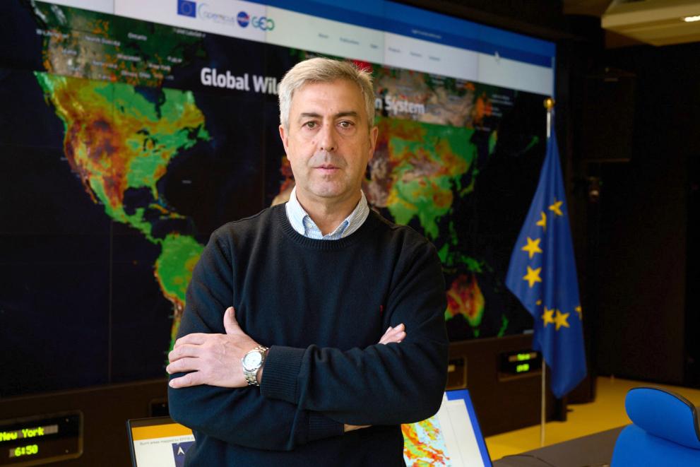Jesús San-Miguel-Ayanz standing in front of a map and an EU flag