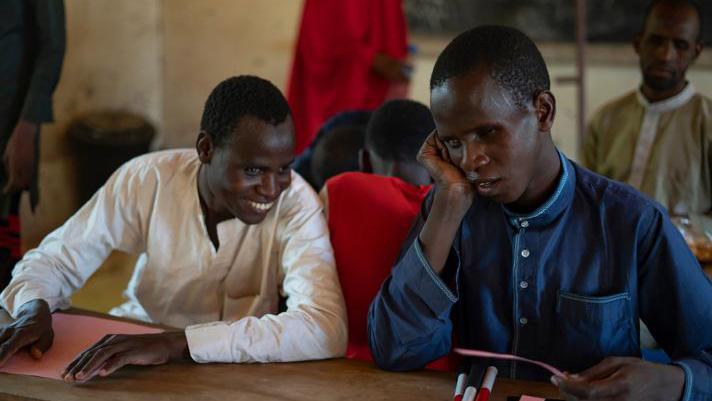 2 boys sitting at a desk in a class room
