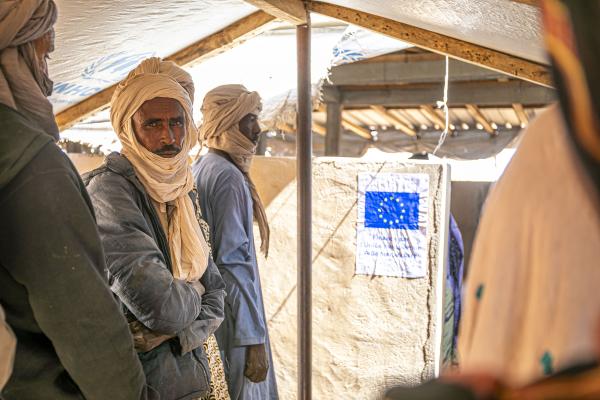 Men queueing up at a aid centre.